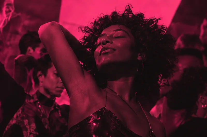 A woman dancing in pink concert light